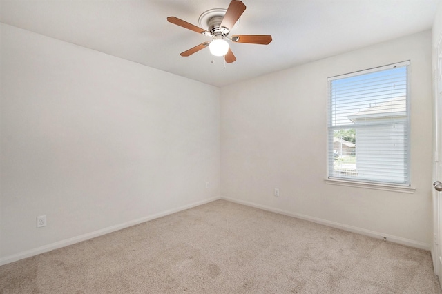 unfurnished room featuring light colored carpet, ceiling fan, and baseboards