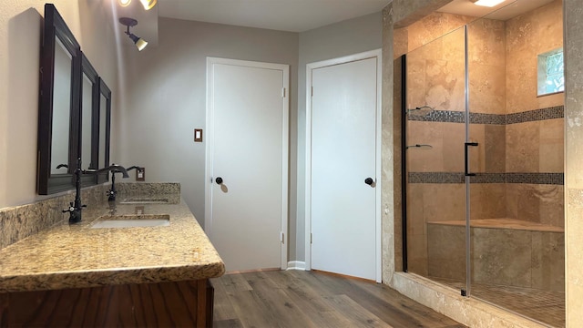 bathroom with double sink vanity, hardwood / wood-style flooring, and walk in shower