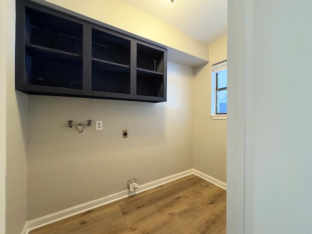 laundry room with electric dryer hookup, hookup for a washing machine, cabinets, and hardwood / wood-style floors