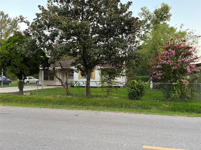 view of property hidden behind natural elements featuring a front lawn