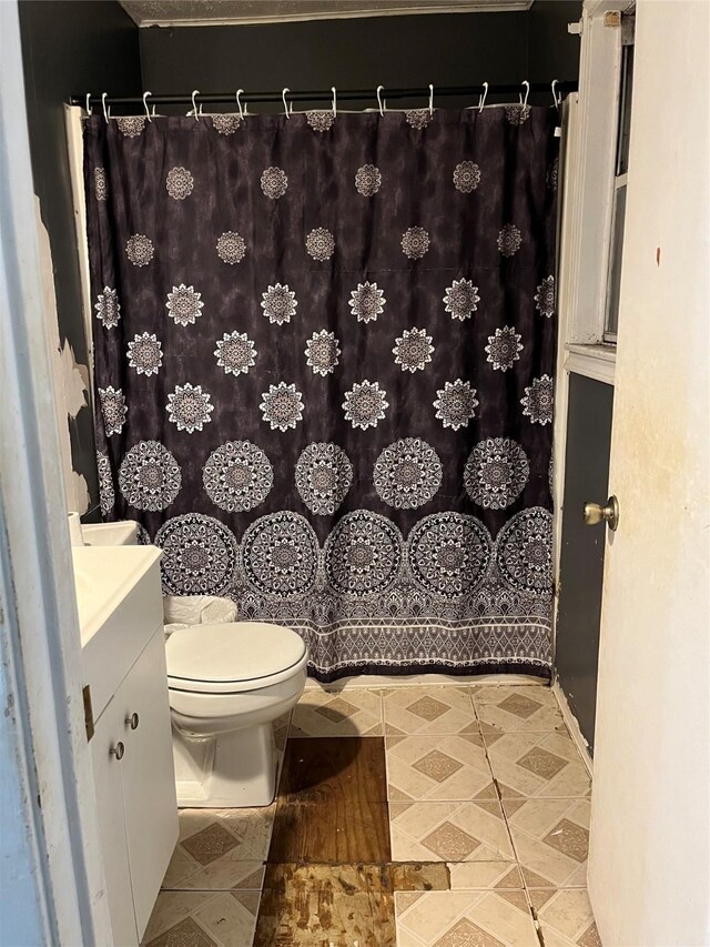 bathroom featuring vanity, tile patterned flooring, and toilet