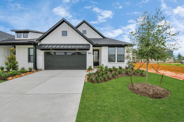 modern farmhouse style home with board and batten siding, a front lawn, concrete driveway, a garage, and a standing seam roof