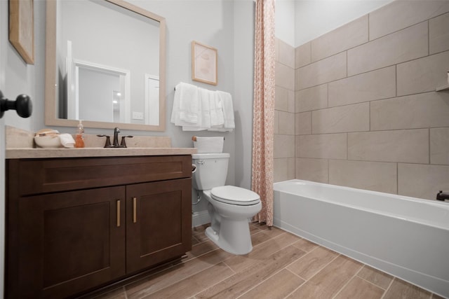 bathroom featuring shower / bath combo with shower curtain, toilet, vanity, and wood finish floors