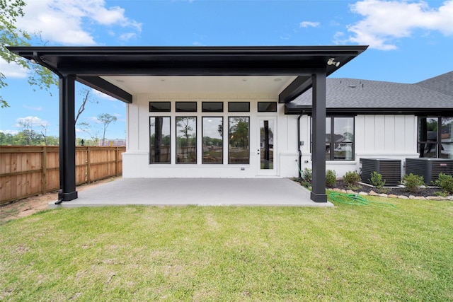 back of house featuring central AC unit, a patio area, fence, and a lawn