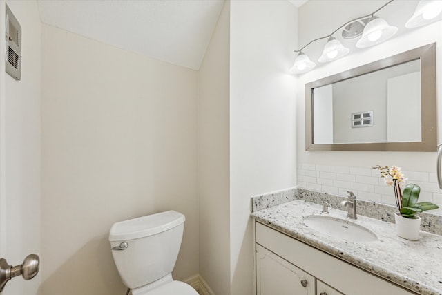 bathroom with toilet, backsplash, and vanity