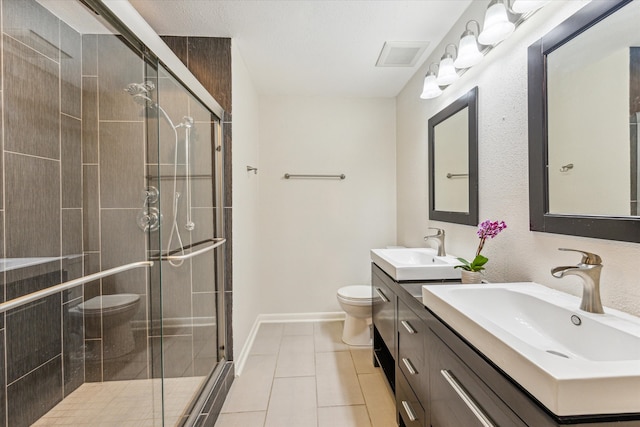 bathroom featuring vanity, a shower with shower door, tile patterned flooring, and toilet