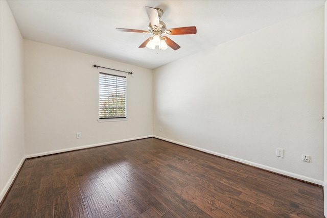 spare room featuring dark wood-type flooring and ceiling fan