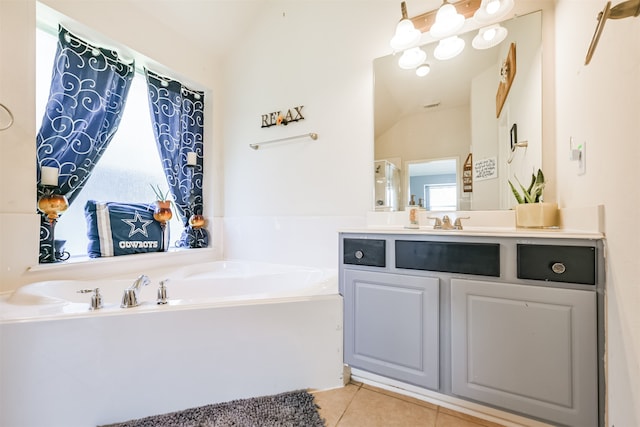 bathroom with vanity, lofted ceiling, a bath, and tile patterned flooring