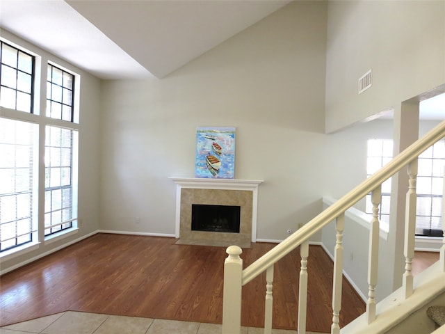 unfurnished living room with hardwood / wood-style flooring, plenty of natural light, and a tile fireplace