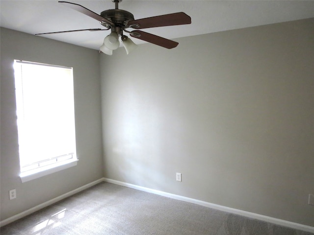 carpeted spare room featuring ceiling fan