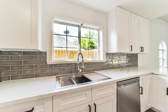 kitchen featuring sink, light stone counters, decorative backsplash, dishwasher, and white cabinets