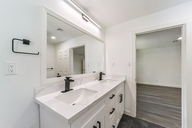 bathroom with double vanity and hardwood / wood-style flooring