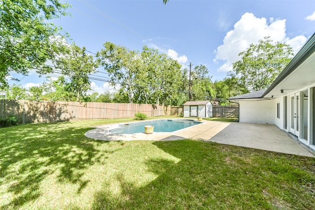 view of yard with a patio area, a shed, and a fenced in pool