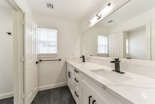 bathroom featuring tile patterned floors, plenty of natural light, and dual bowl vanity