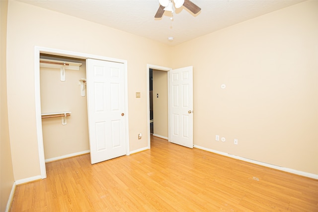 unfurnished bedroom with ceiling fan, light wood-type flooring, and a closet