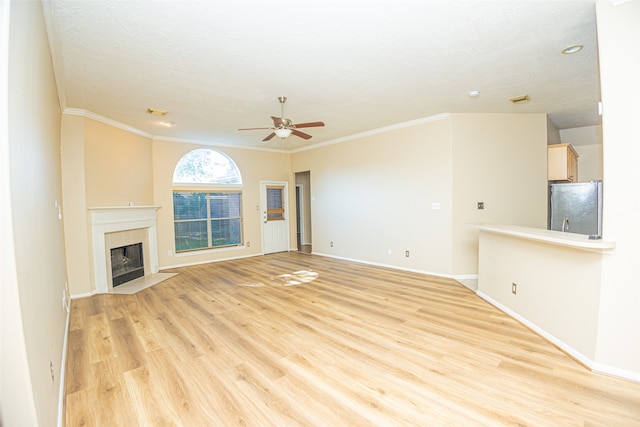 unfurnished living room featuring a fireplace, light wood-type flooring, ornamental molding, and ceiling fan