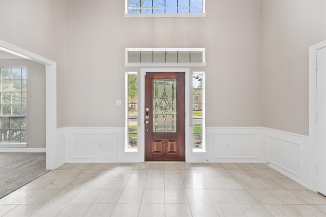 entryway featuring a towering ceiling and light tile patterned flooring