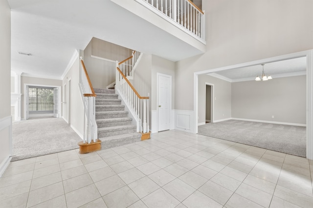 entryway featuring light tile patterned flooring, ornamental molding, and an inviting chandelier