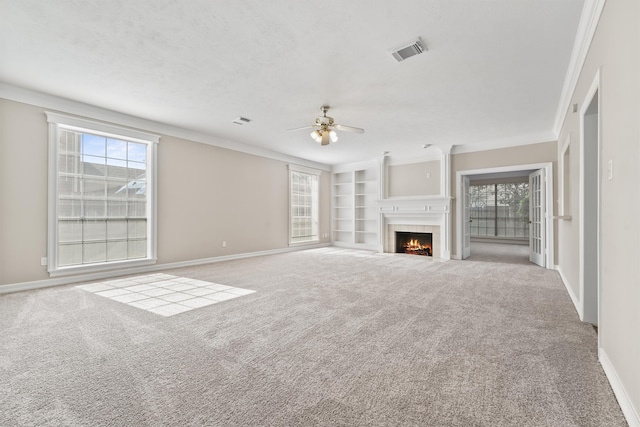 unfurnished living room with carpet floors, crown molding, and a healthy amount of sunlight