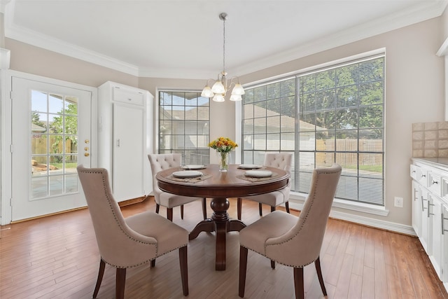 dining area featuring a chandelier, ornamental molding, and hardwood / wood-style flooring