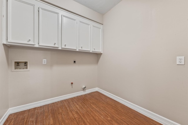 washroom with hookup for a washing machine, hookup for a gas dryer, cabinet space, wood finished floors, and baseboards