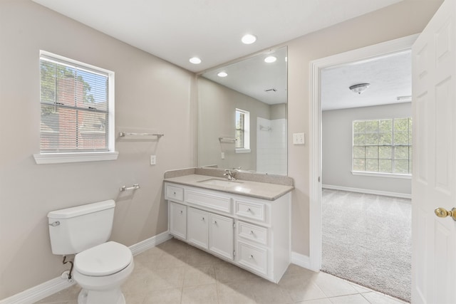 bathroom with plenty of natural light, toilet, tile patterned floors, and vanity