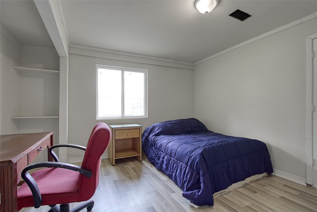 bedroom featuring light hardwood / wood-style flooring and crown molding