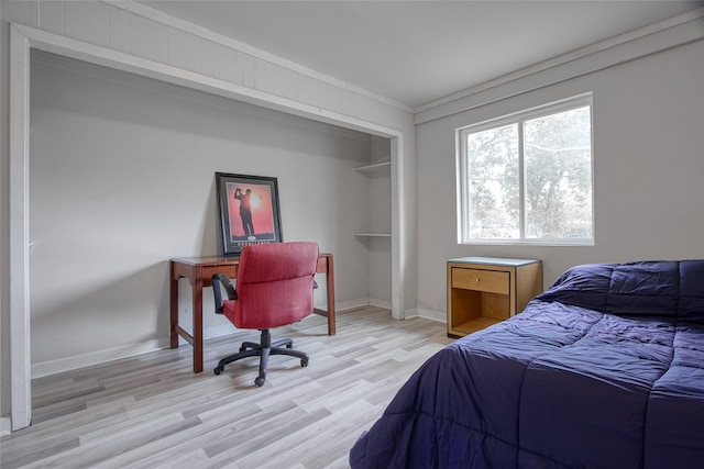 bedroom with crown molding and light hardwood / wood-style floors