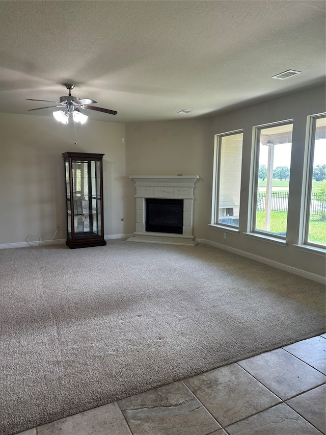 unfurnished living room featuring ceiling fan, light colored carpet, and a textured ceiling