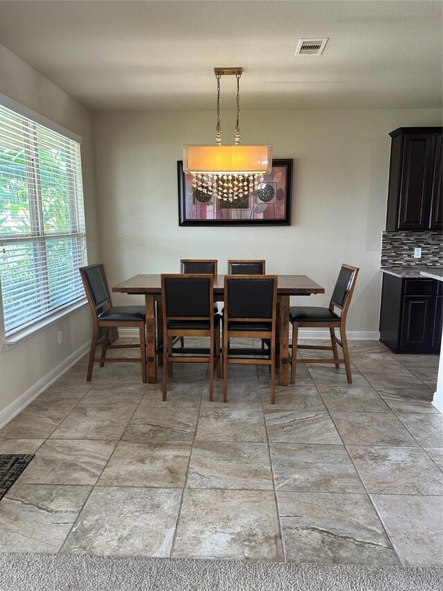 tiled dining room featuring a chandelier