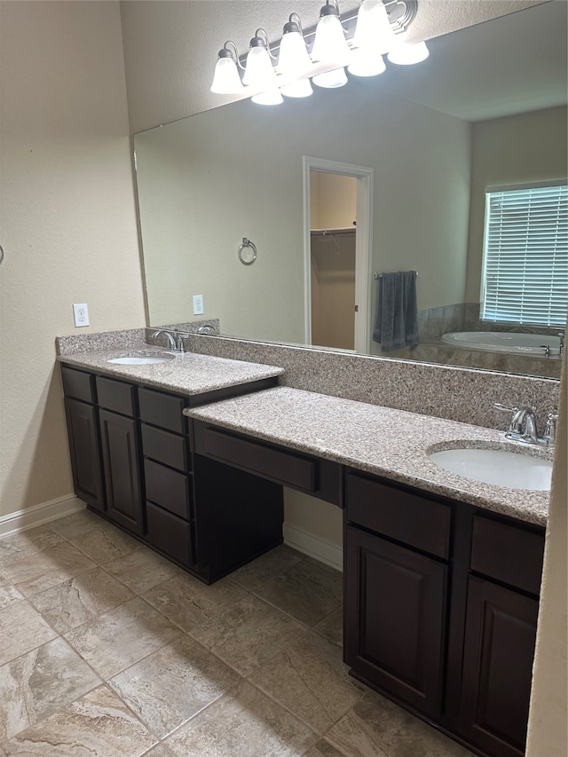 bathroom featuring a bathtub, double sink vanity, and tile patterned floors