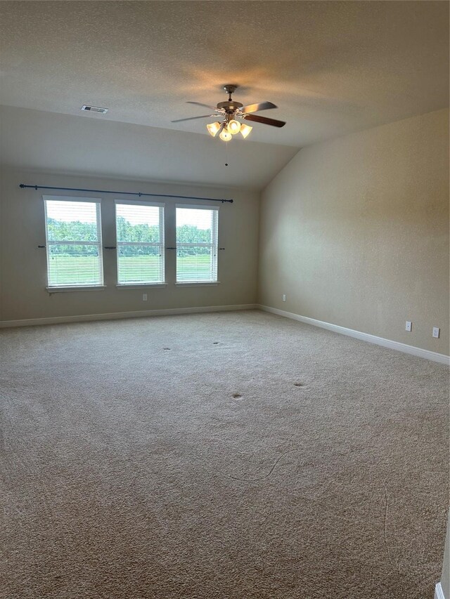 carpeted empty room featuring ceiling fan, a textured ceiling, and lofted ceiling