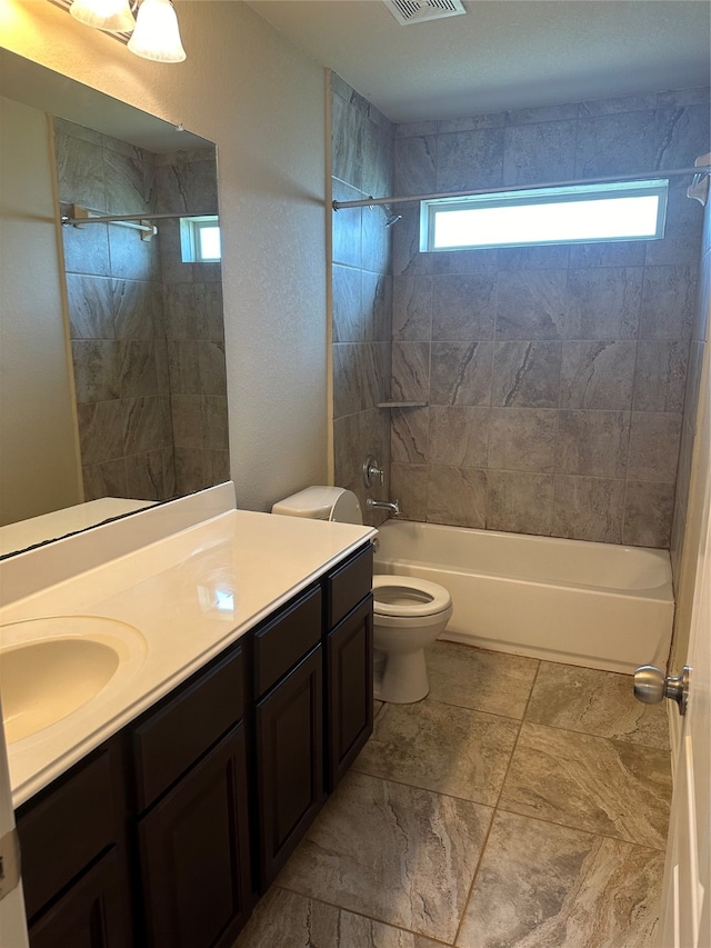 full bathroom with tile patterned flooring, tiled shower / bath combo, a healthy amount of sunlight, and toilet