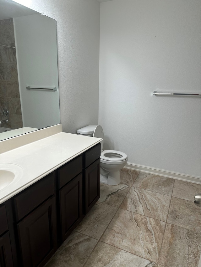 bathroom featuring tile patterned flooring, vanity, and toilet