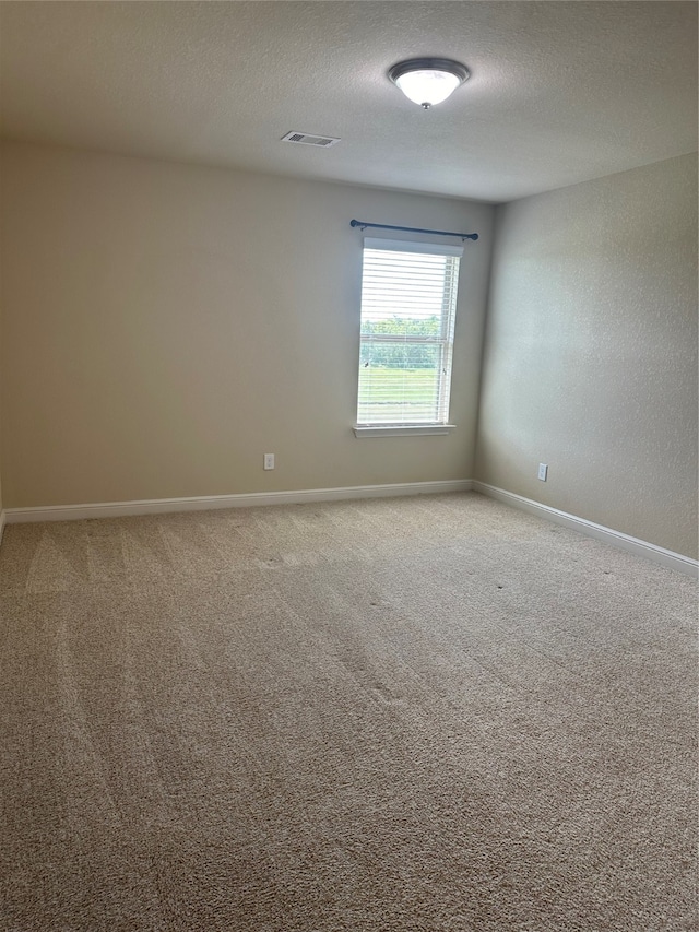 carpeted spare room featuring a textured ceiling