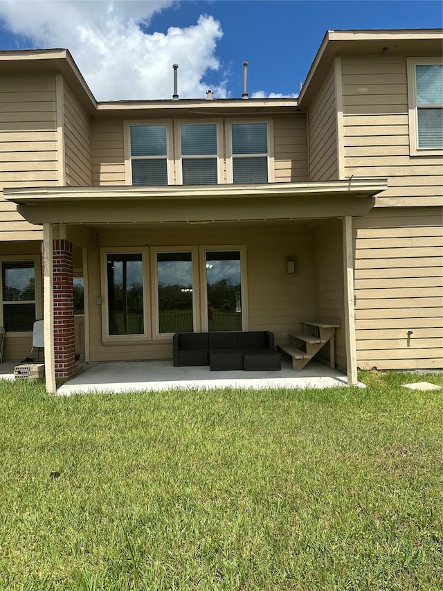 back of property featuring a lawn, a patio area, and outdoor lounge area