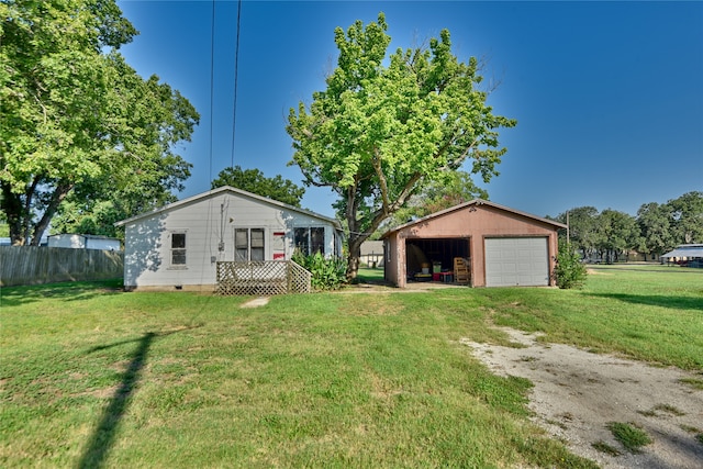 view of front of property with a front yard, a garage, and an outbuilding