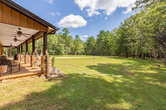 view of yard featuring ceiling fan and a wooden deck