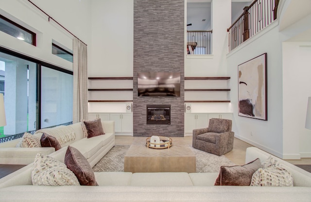 living room with a fireplace and a towering ceiling