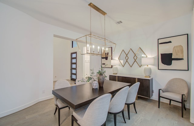 dining room with a notable chandelier and light hardwood / wood-style flooring