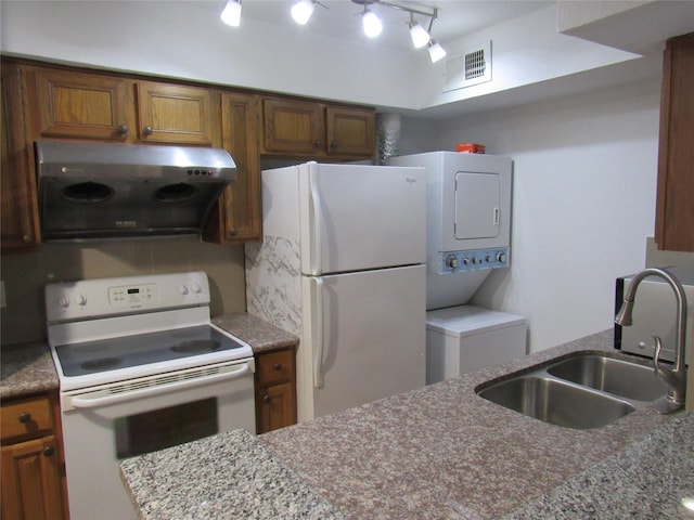 2110 Wilcrest Dr Unit 123, Houston, TX 77042 - kitchen featuring stacked washer / drying machine, white appliances, brown cabinetry, ventilation hood, and track lighting