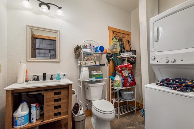 bathroom featuring vanity, toilet, and stacked washer / dryer