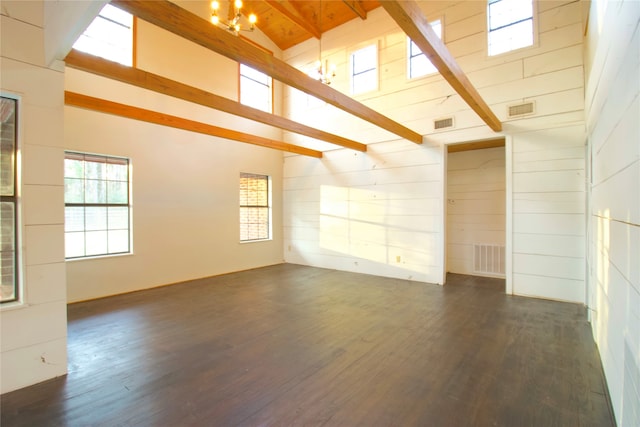 spare room with beam ceiling, dark wood-type flooring, and a chandelier