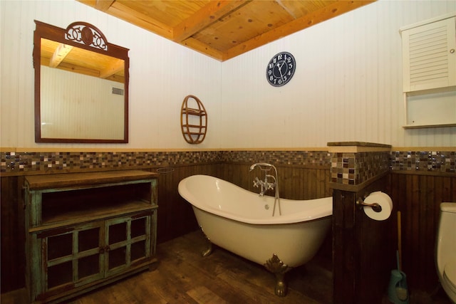 bathroom featuring a bathtub, hardwood / wood-style flooring, wood ceiling, and toilet