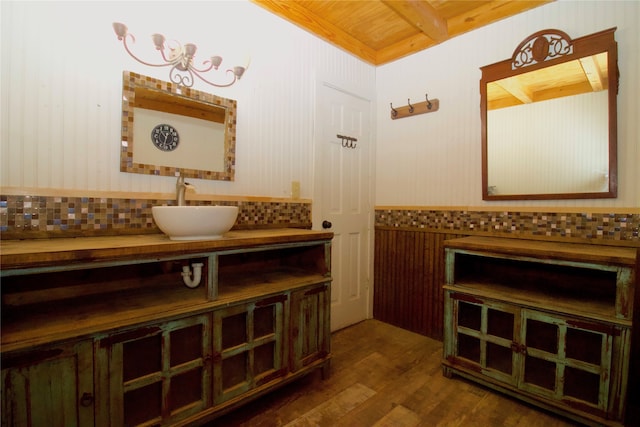 bathroom with backsplash, wooden ceiling, hardwood / wood-style floors, and vanity