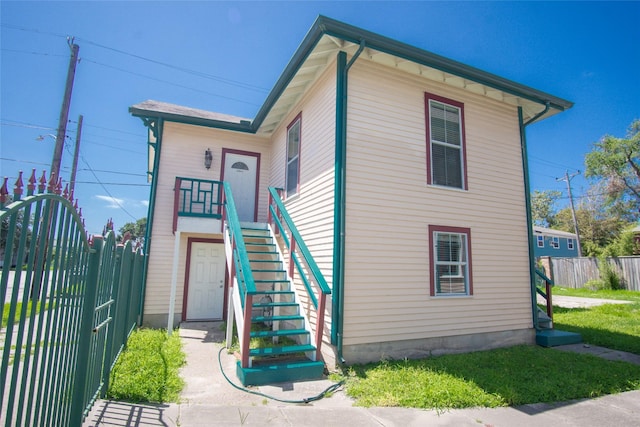 view of front of home featuring stairway and fence