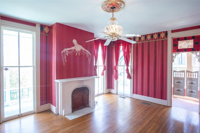 unfurnished living room featuring hardwood / wood-style floors, a wealth of natural light, and ceiling fan