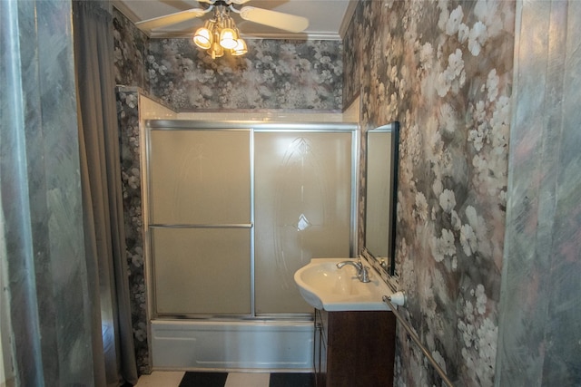 full bath featuring wallpapered walls, ceiling fan, bath / shower combo with glass door, and vanity