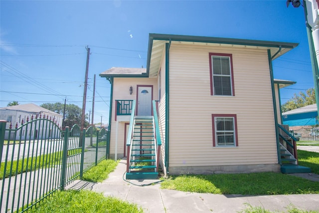 view of front facade with a gate, fence, and stairway