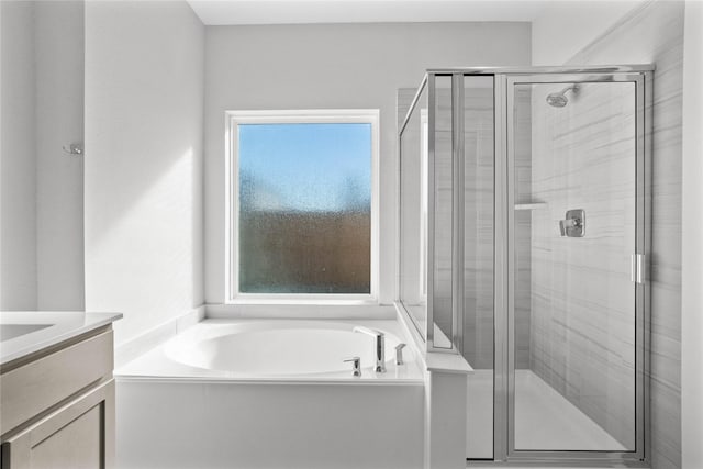 bathroom with vanity and shower with separate bathtub